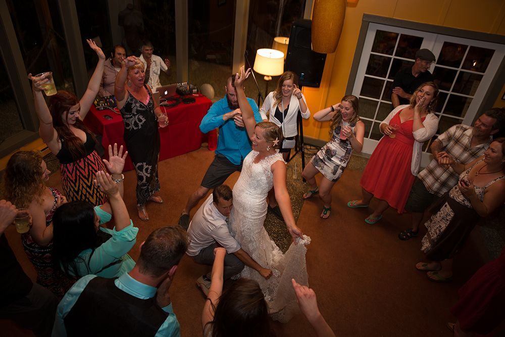 Lively dance floor scene at an indoor wedding reception with guests enjoying the celebration.