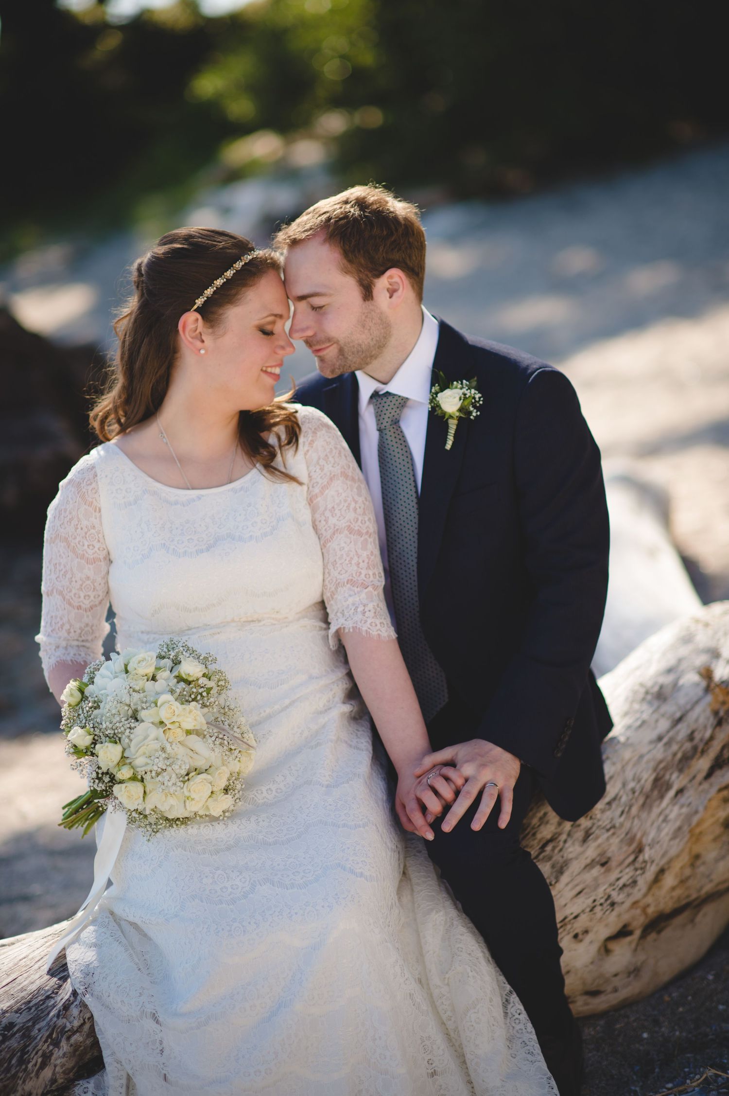 Intimate wedding portraits captured on rocky beach showing tender moments between newlyweds.