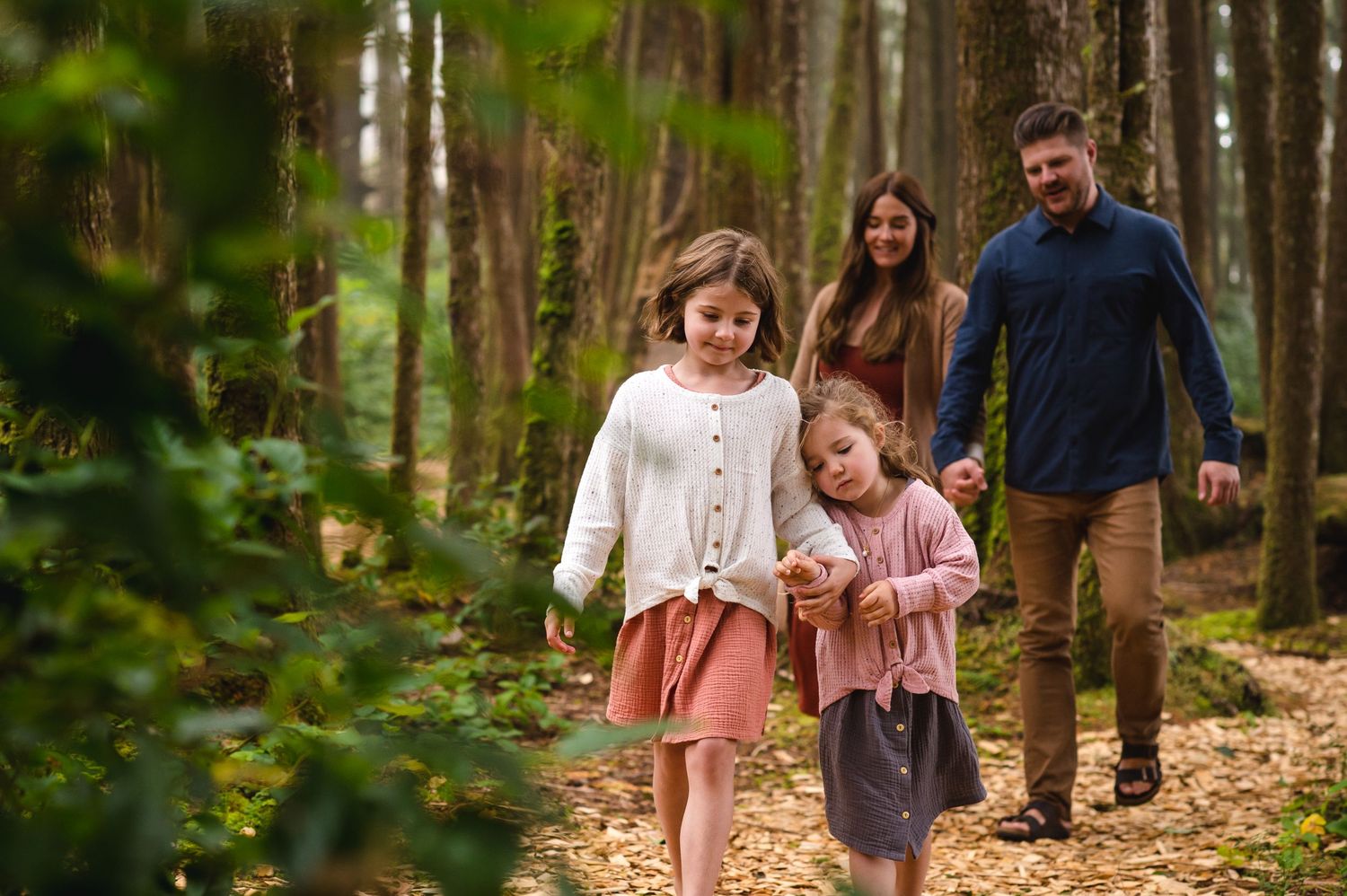 Candid family moments photographed along a forest trail.