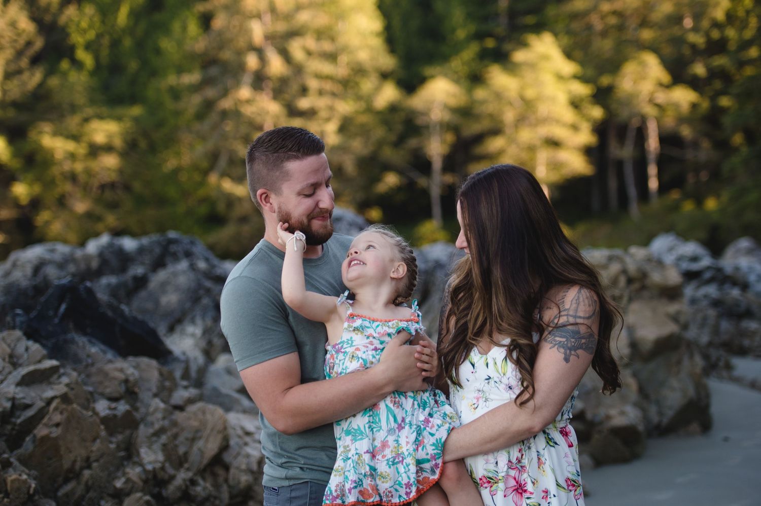 A playful family portrait with coordinated outfits against a scenic outdoor backdrop.