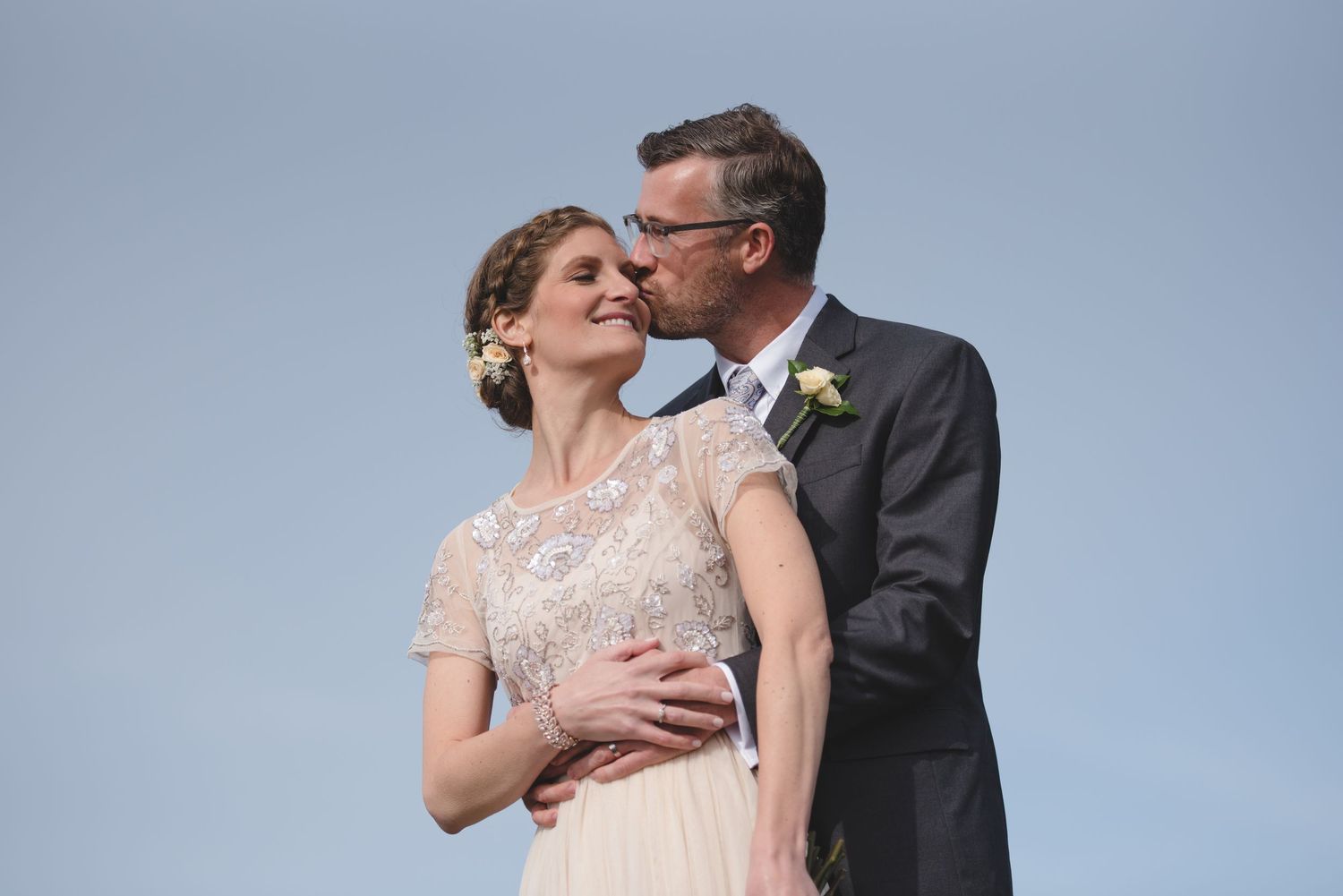 A couple embraces during their intimate mountain top wedding ceremony.