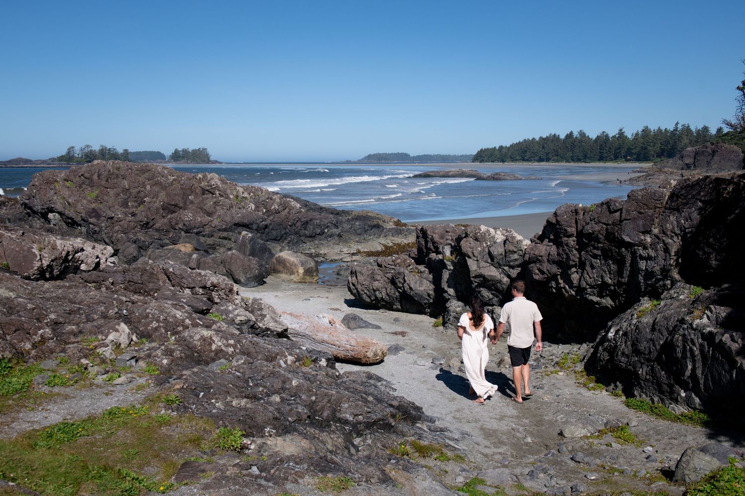 Wide angle view of a rugged Pacific Northwest coastline with rocky outcrops and sandy beach.