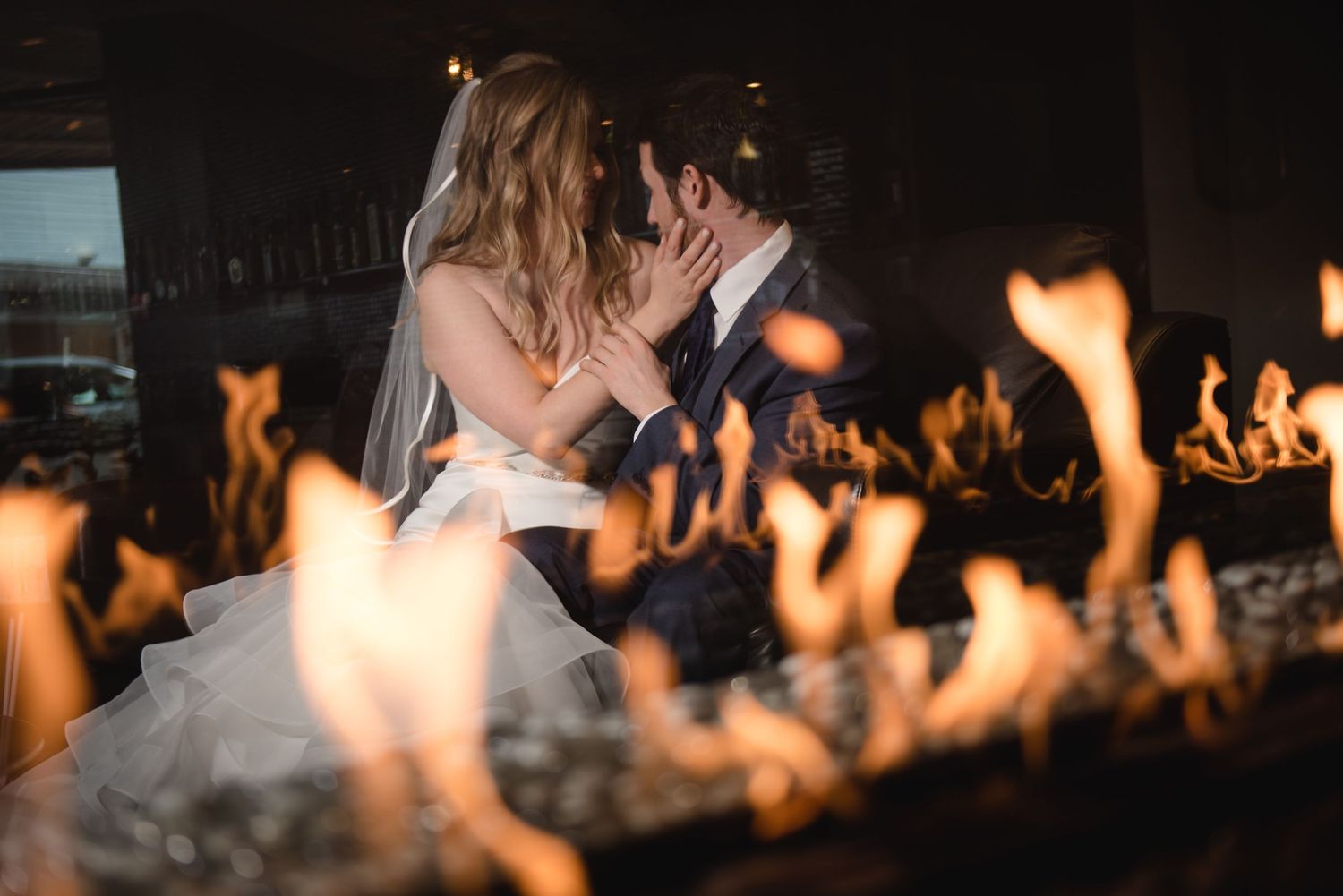 Silhouettes of wedding guests dancing behind a row of glowing flames.