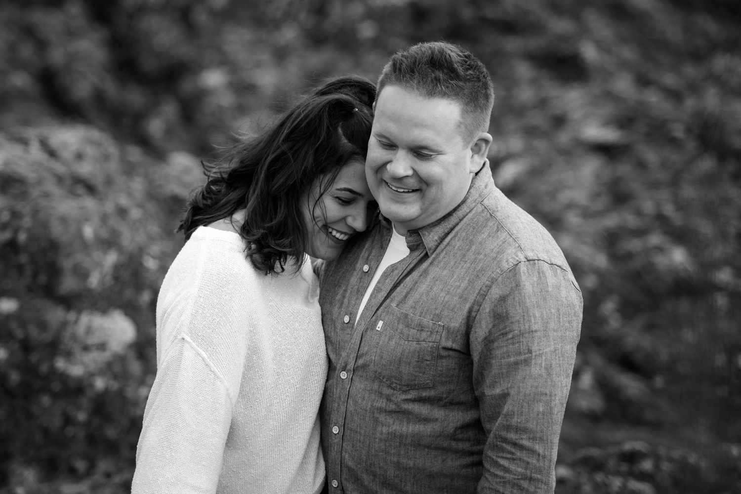 A couple shares a romantic moment together against a dark background.