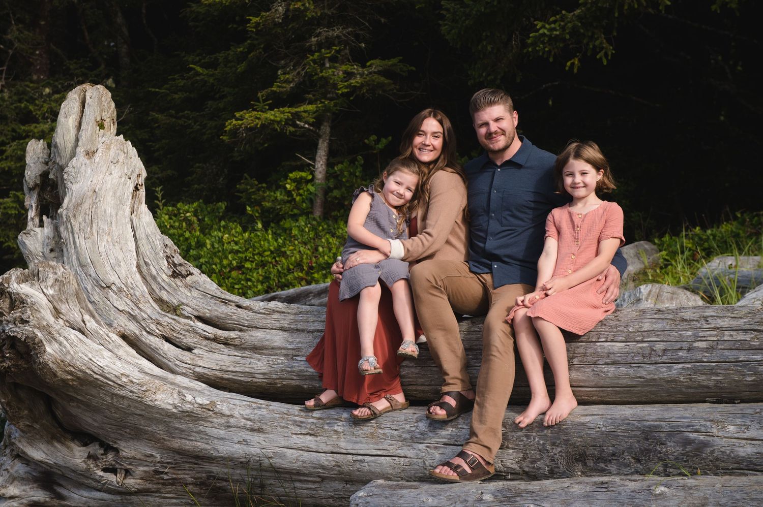 Family portraits taken on a fallen tree trunk at a Pacific Northwest beach.