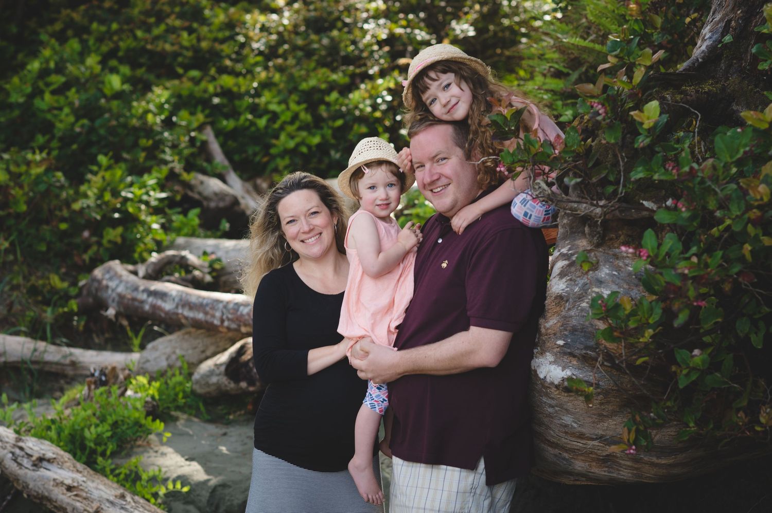 A loving family moment captured outdoors with natural greenery in the background.