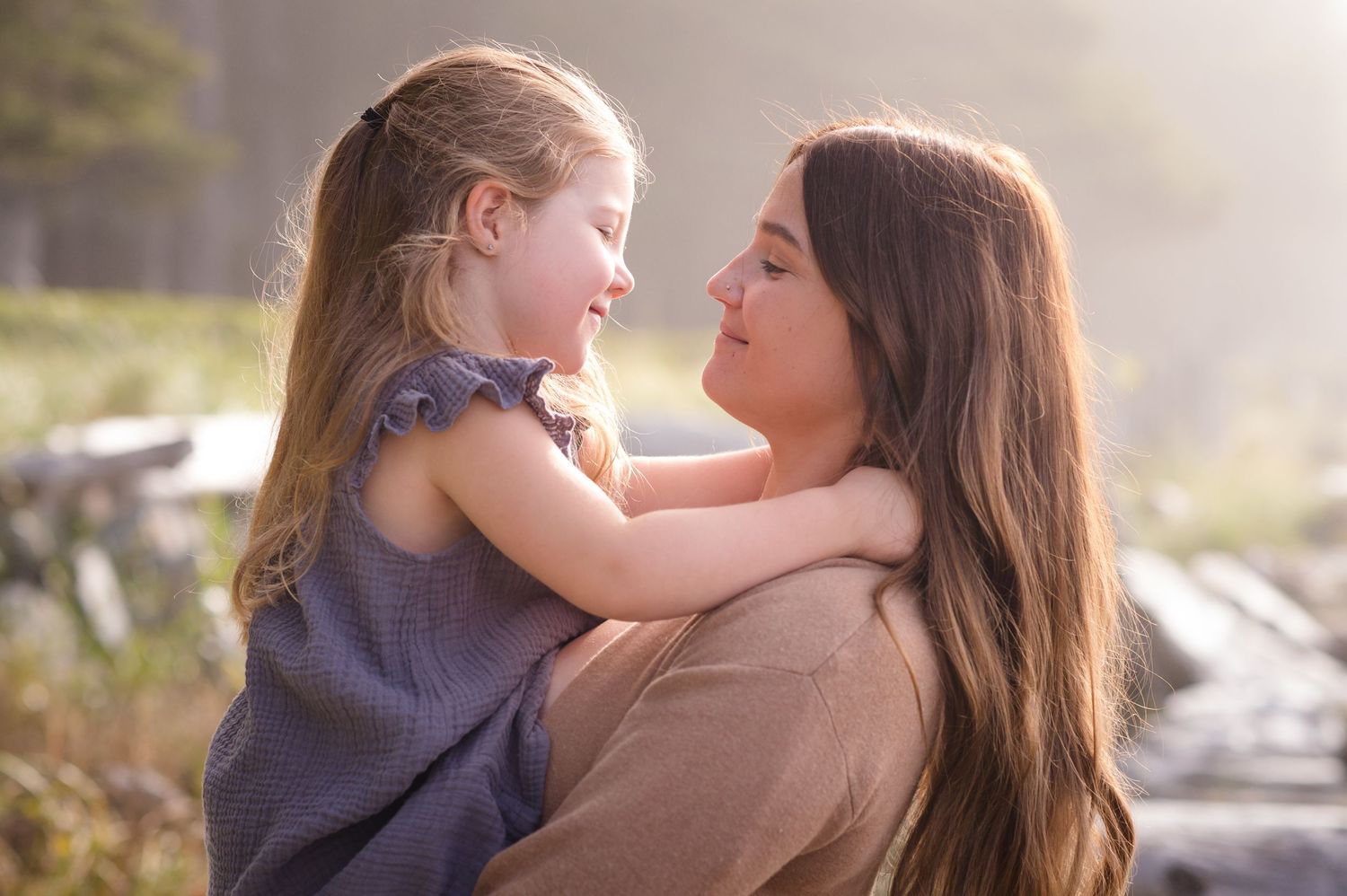 Loving family interactions captured in soft golden hour lighting at the beach.