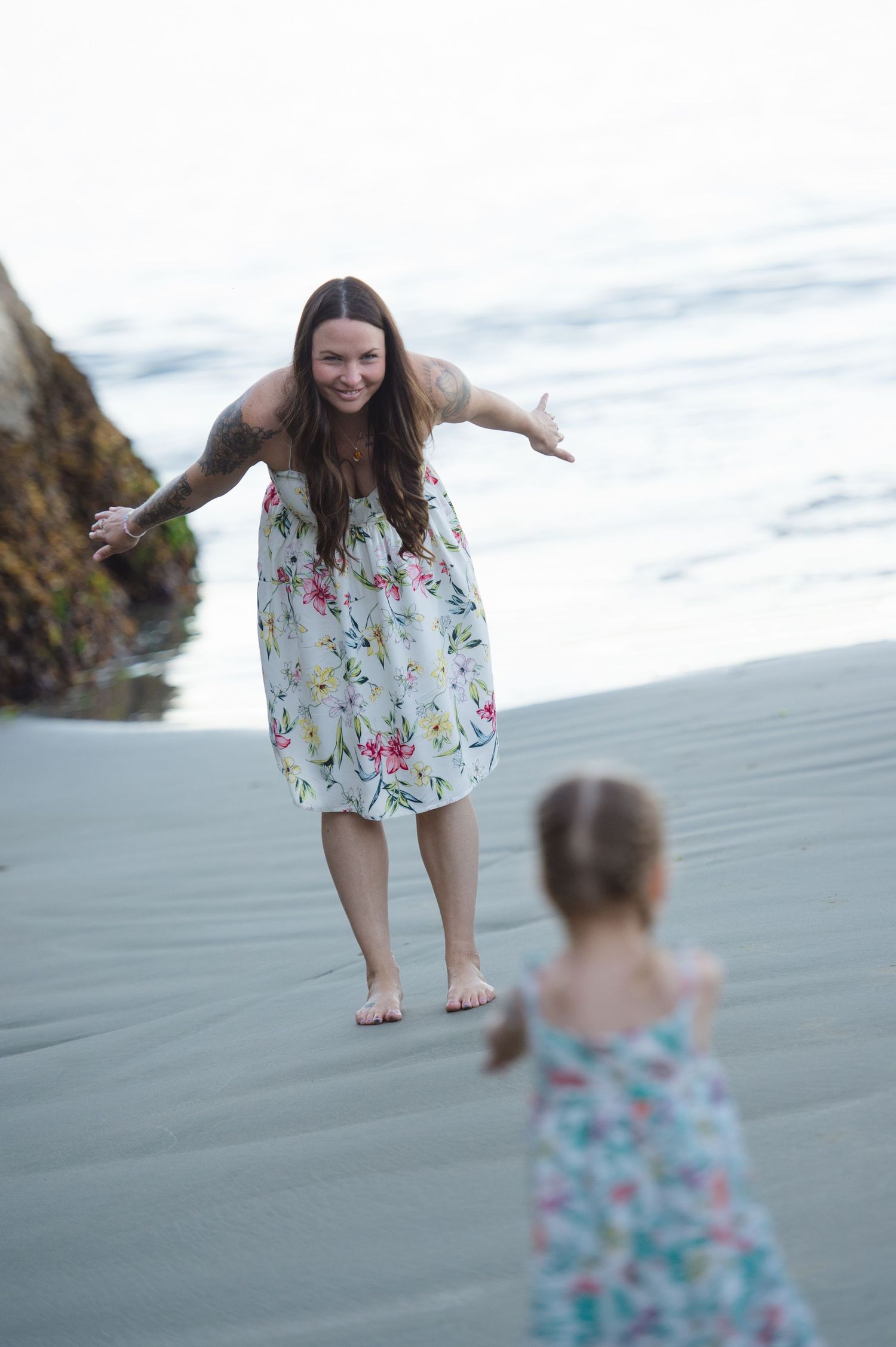 Candid moments captured on a sandy beach with matching floral outfits.
