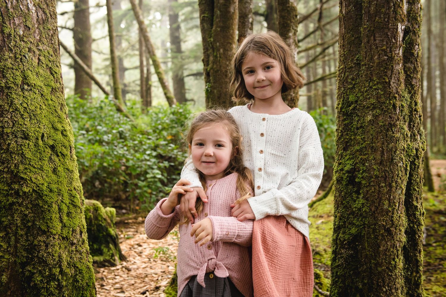 Sweet family interaction captured in a sunlit forest setting.