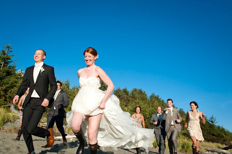 Wedding party walking along coastal path under bright blue sky.