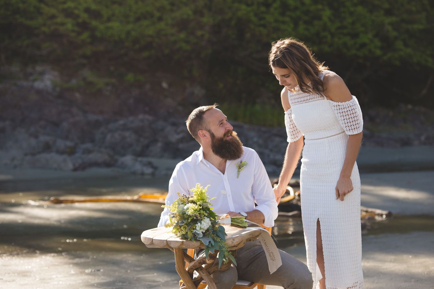 Couples in white outfits share intimate moments together in a sun-lit outdoor setting.
