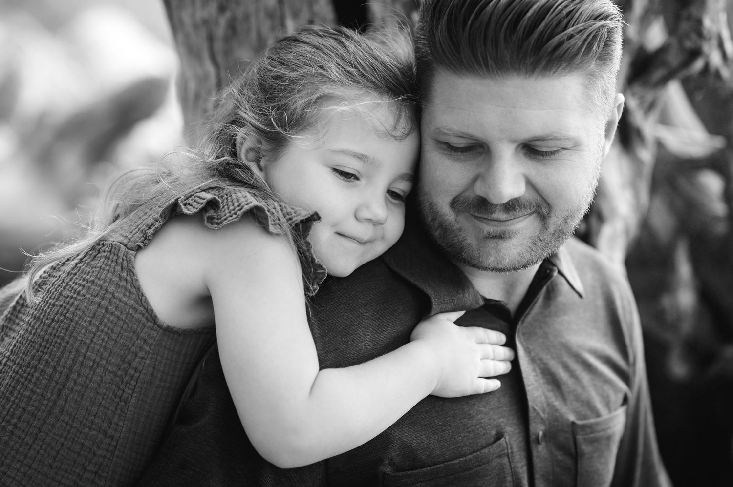A tender black and white portrait showing a sweet embrace outdoors.