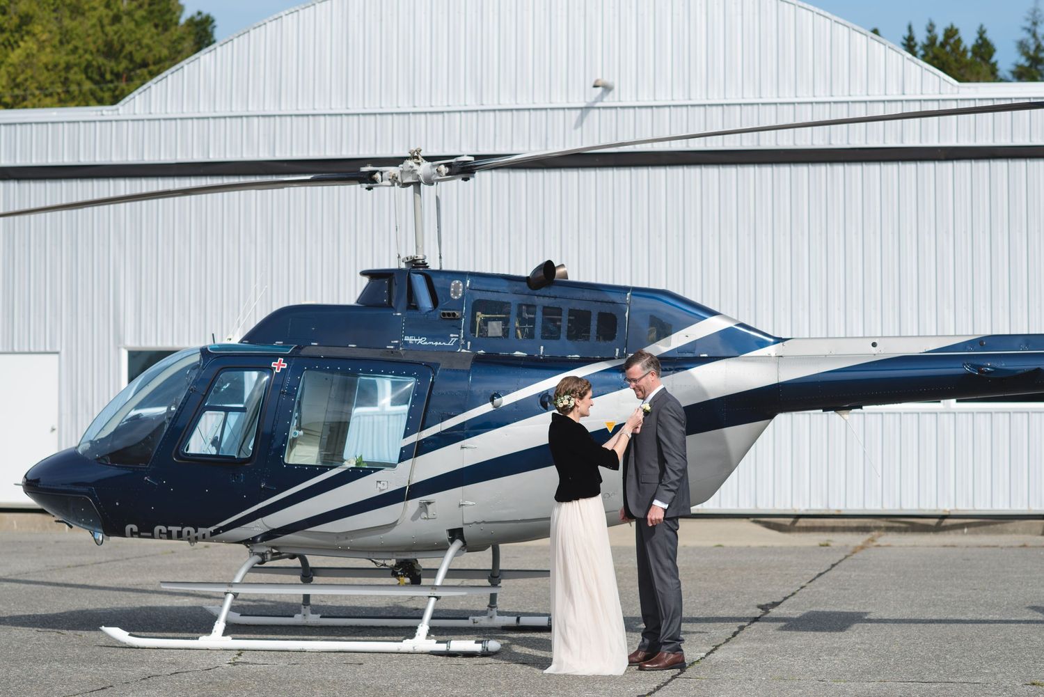 Wedding photography session with helicopters lined up at an airfield.