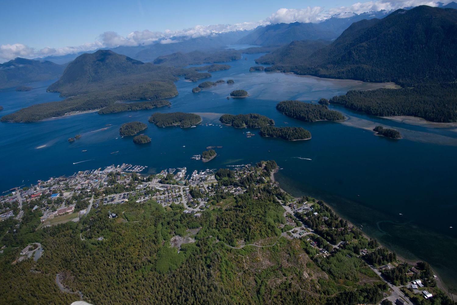 Aerial panoramic view of mountains and fjords in Norway showing coastal settlements and winding waterways.