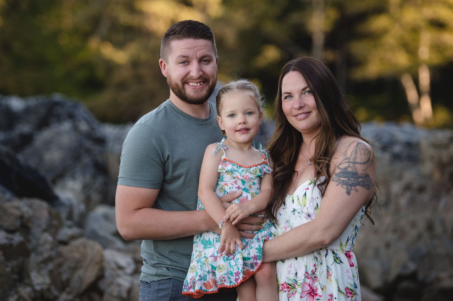 A family portrait taken outdoors with matching floral outfits against rocky terrain.