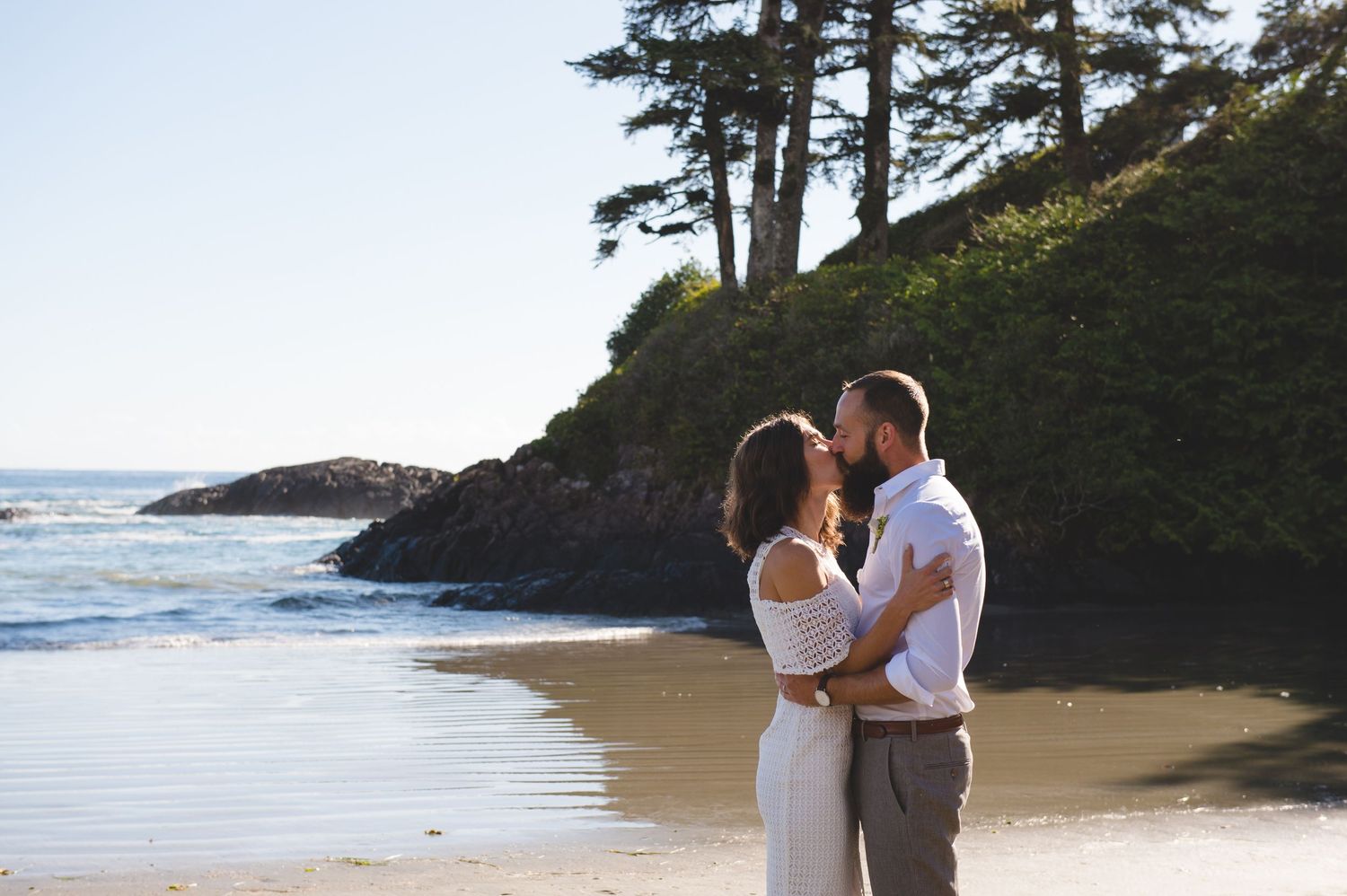 Scenic beach cove with rocky cliffs and evergreen trees along the Pacific Northwest coastline.