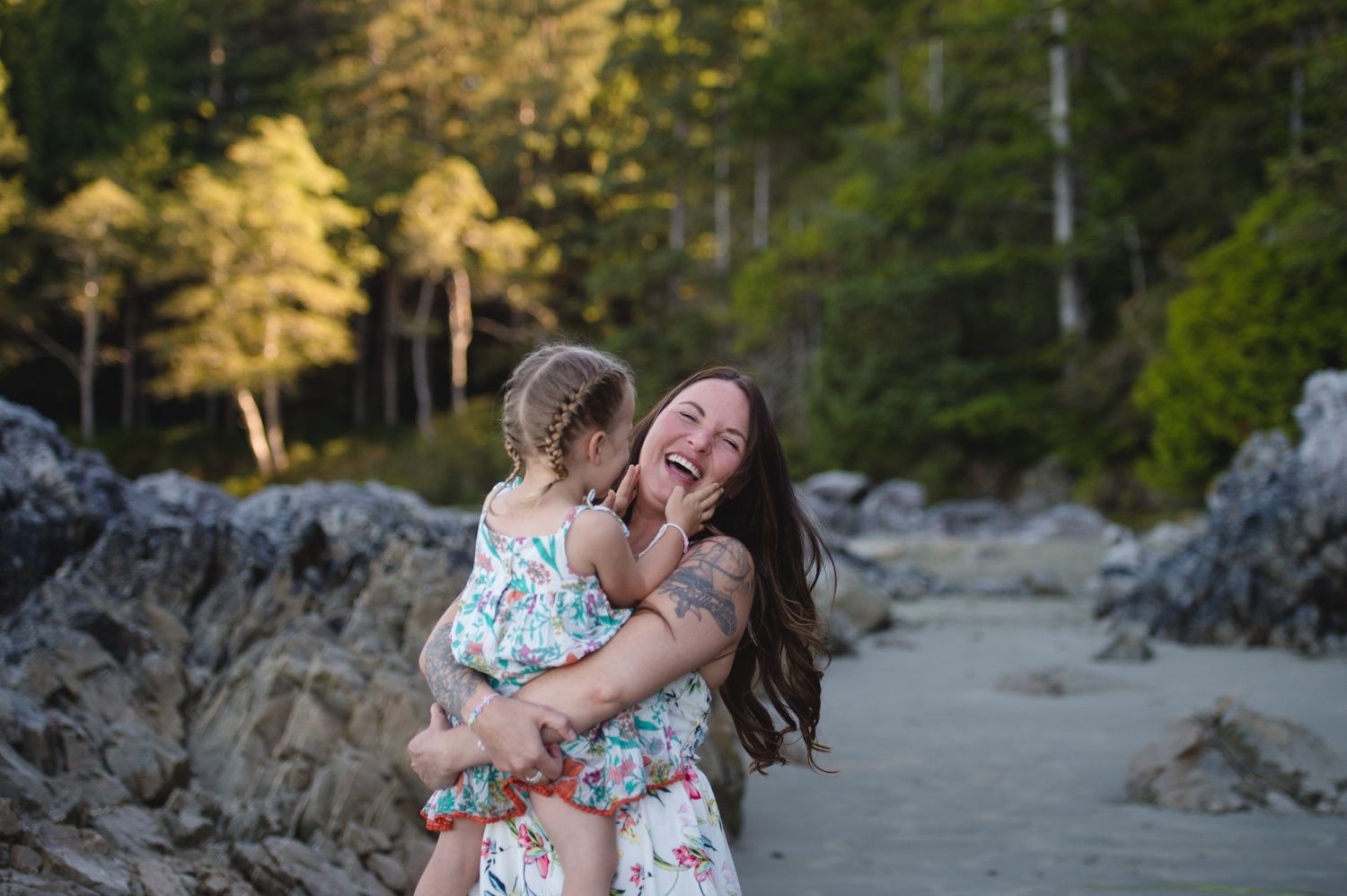 Sunset beach photoshoot capturing candid loving moments among rocky coastal scenery.
