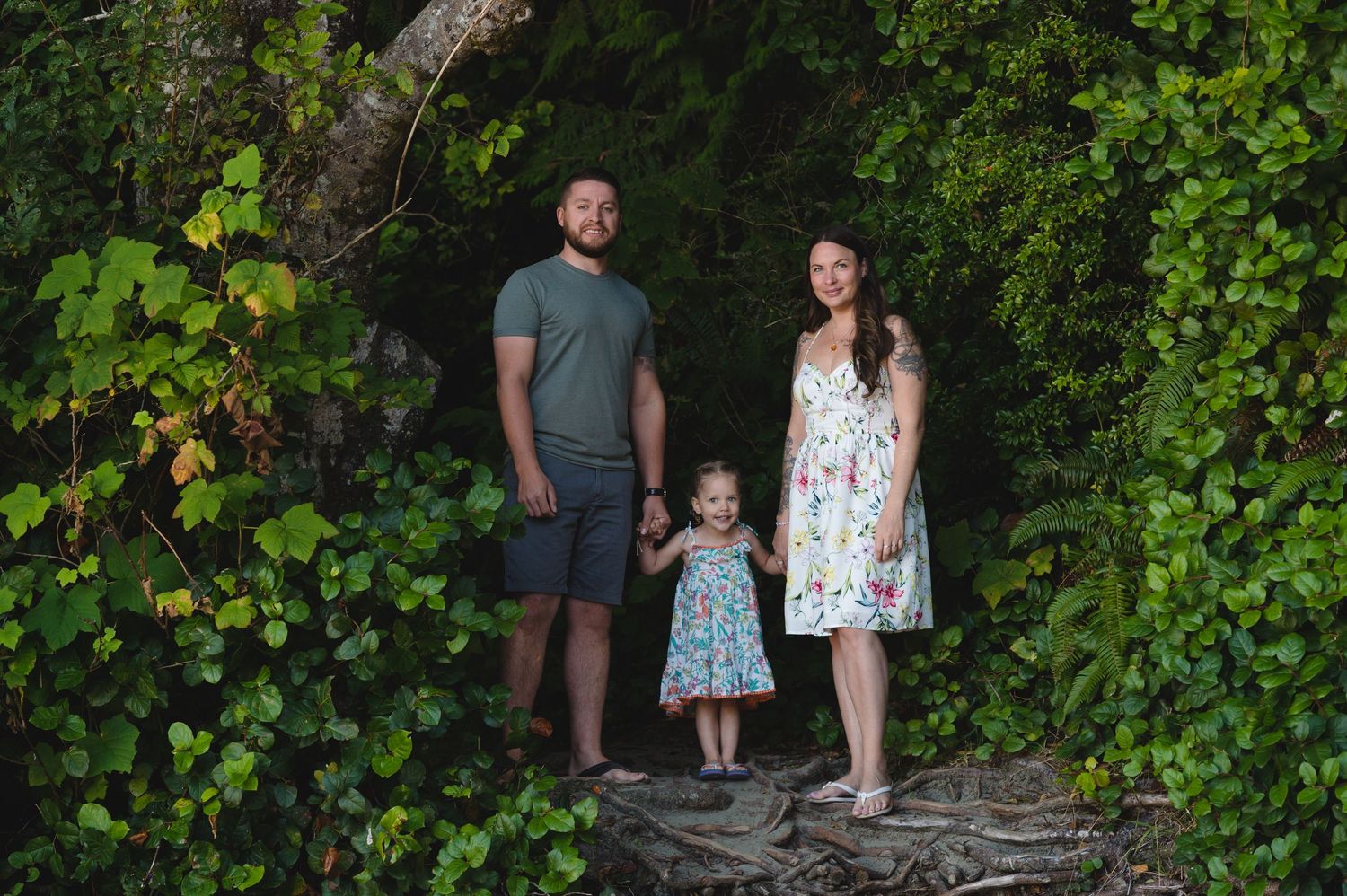 Group enjoying nature walk through lush green forest path near ocean.