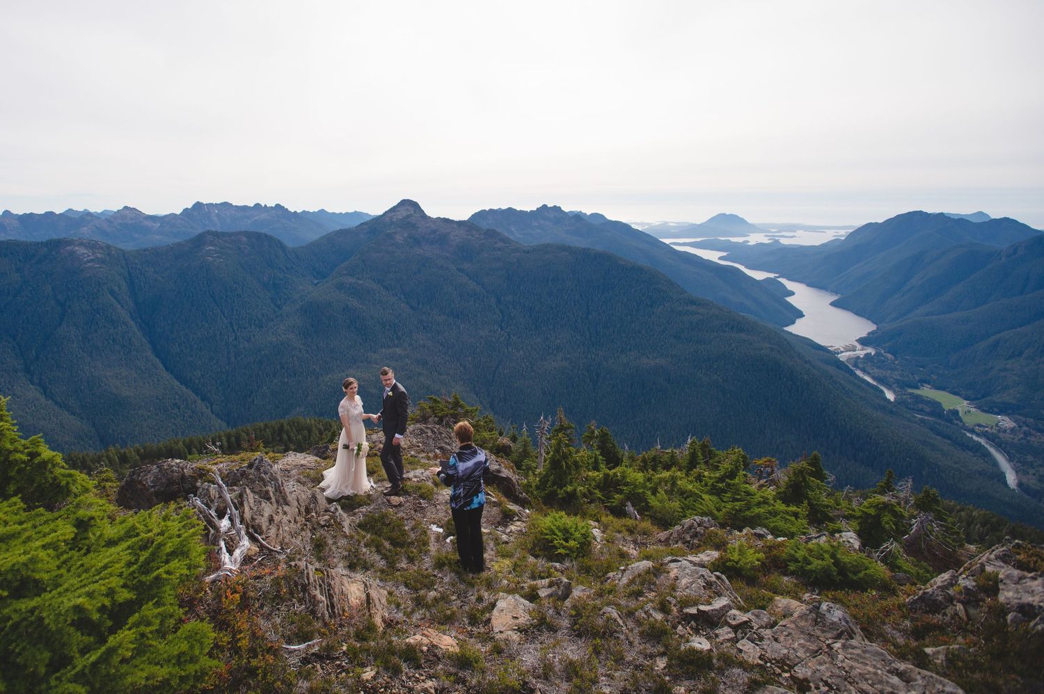 Dramatic mountain ranges and valleys stretch into the distance under cloudy skies.
