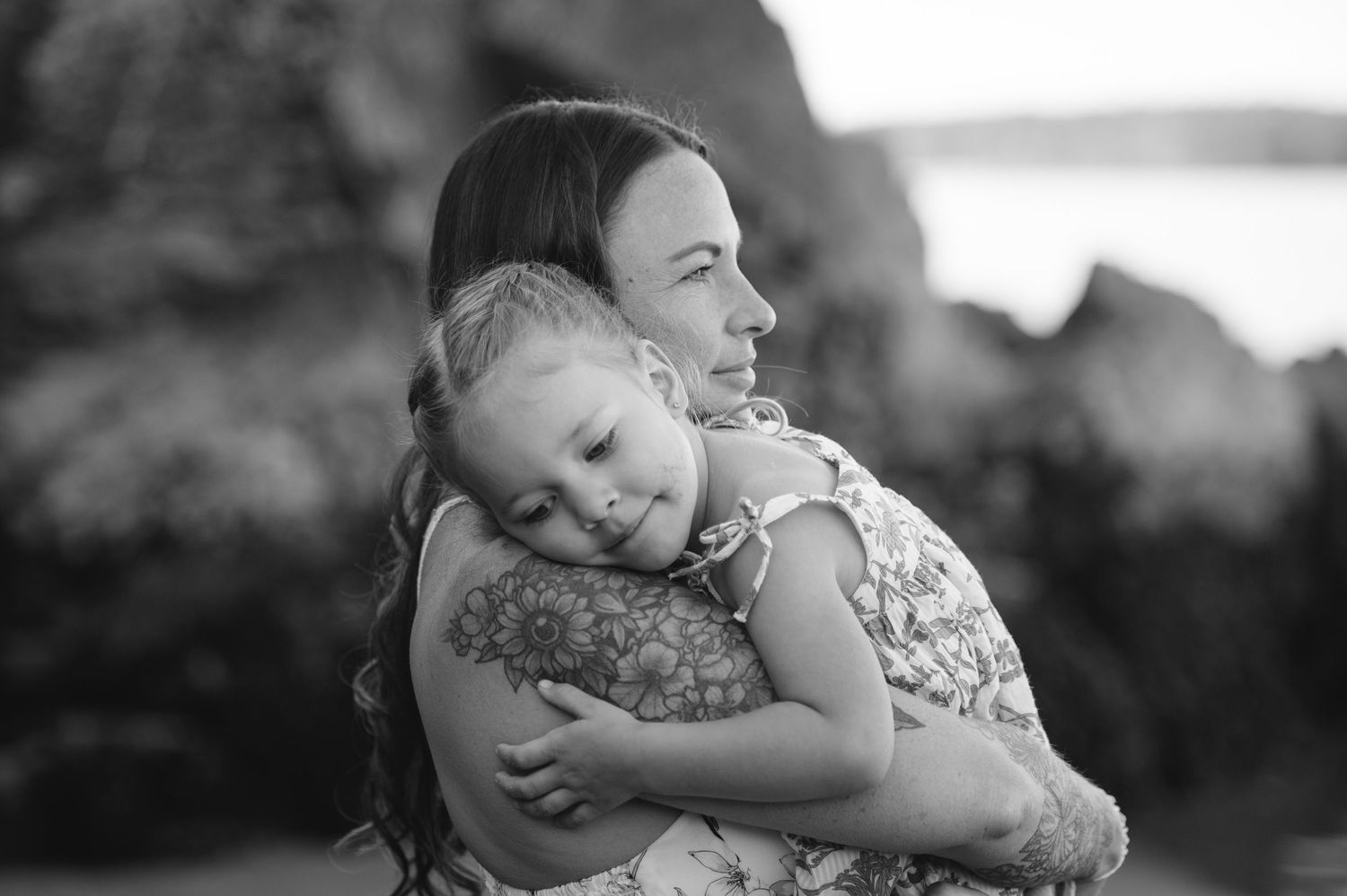 Black and white portrait of tender family embrace on beach.