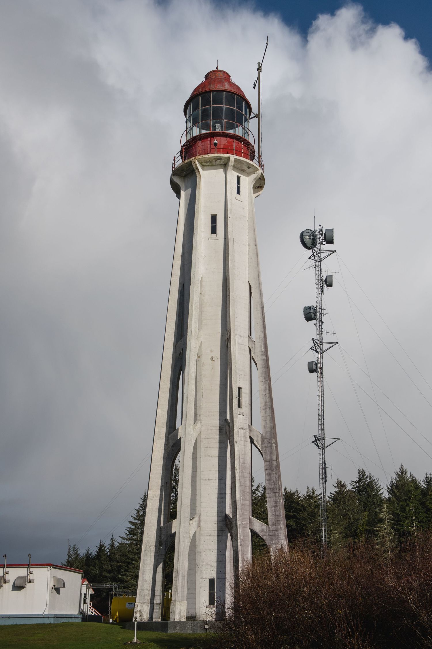 Estevan lighthouse tower with red top photographed from different angles against cloudy sky.