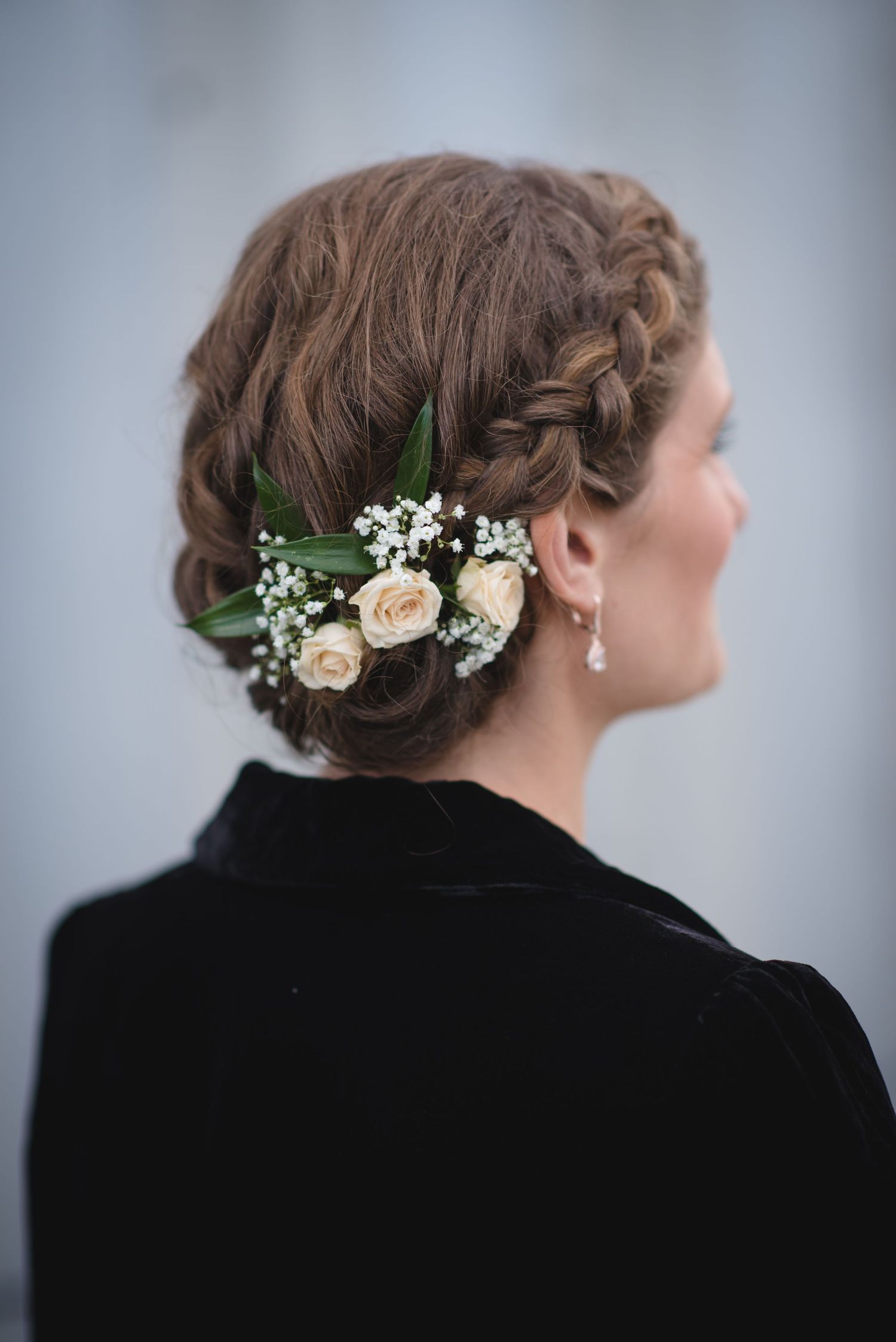 Elegant bridal hairstyle adorned with delicate white flowers and greenery.
