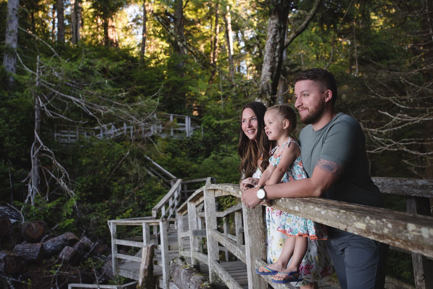 Group gathered on weathered wooden walkway in forest during golden hour.