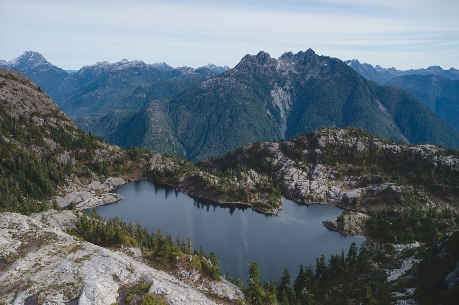 Panoramic view of rugged mountain peaks and alpine lakes in a pristine wilderness landscape.