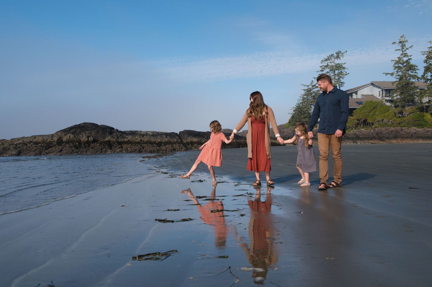 People walking barefoot in the shallow waves at the beach.