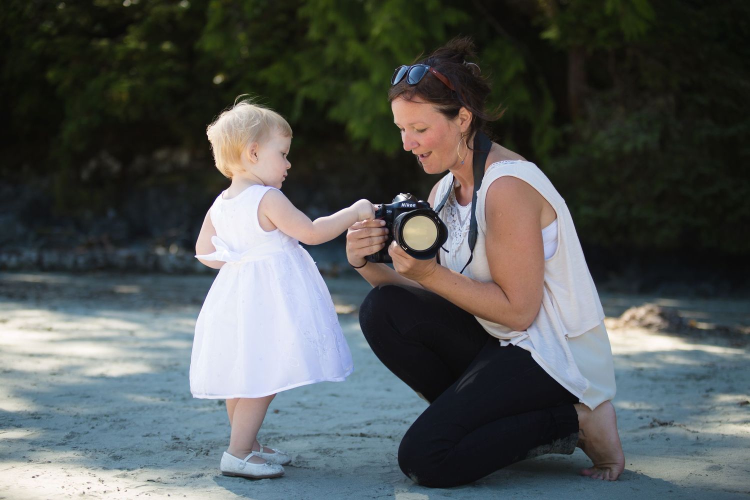 Family photography session on a sunny beach with natural lighting.