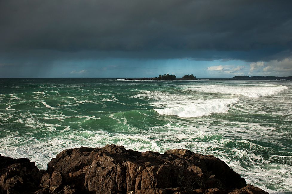 Dramatic seascape with crashing waves against rocky Pacific Northwest coastline.