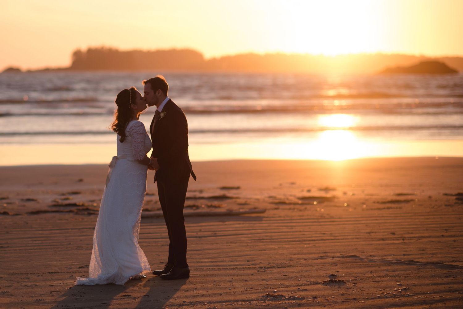 Romantic beach wedding photography session during golden hour sunset.