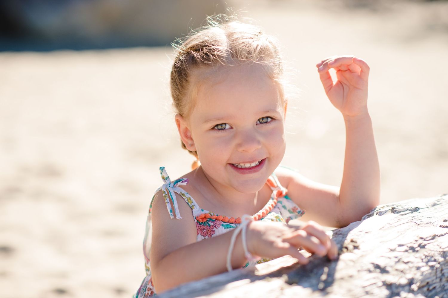 Sunlit portrait of child with curly hair looking up with dreamy expression.