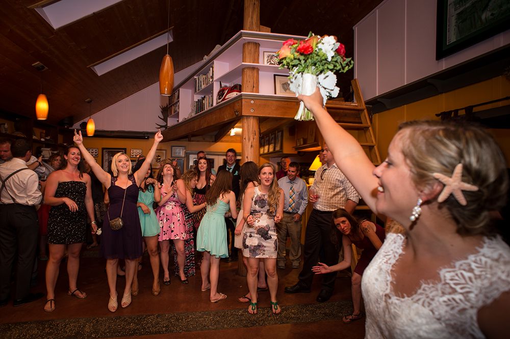 Wedding reception dance party with guests celebrating under warm lighting.