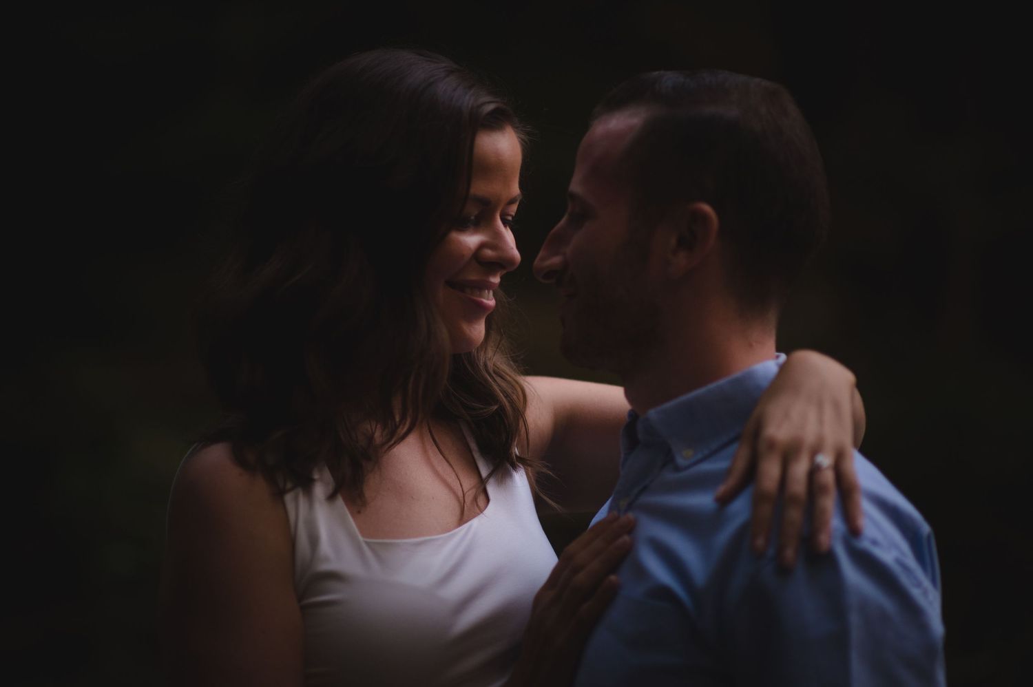 A romantic silhouette of a couple embracing against a dark background.