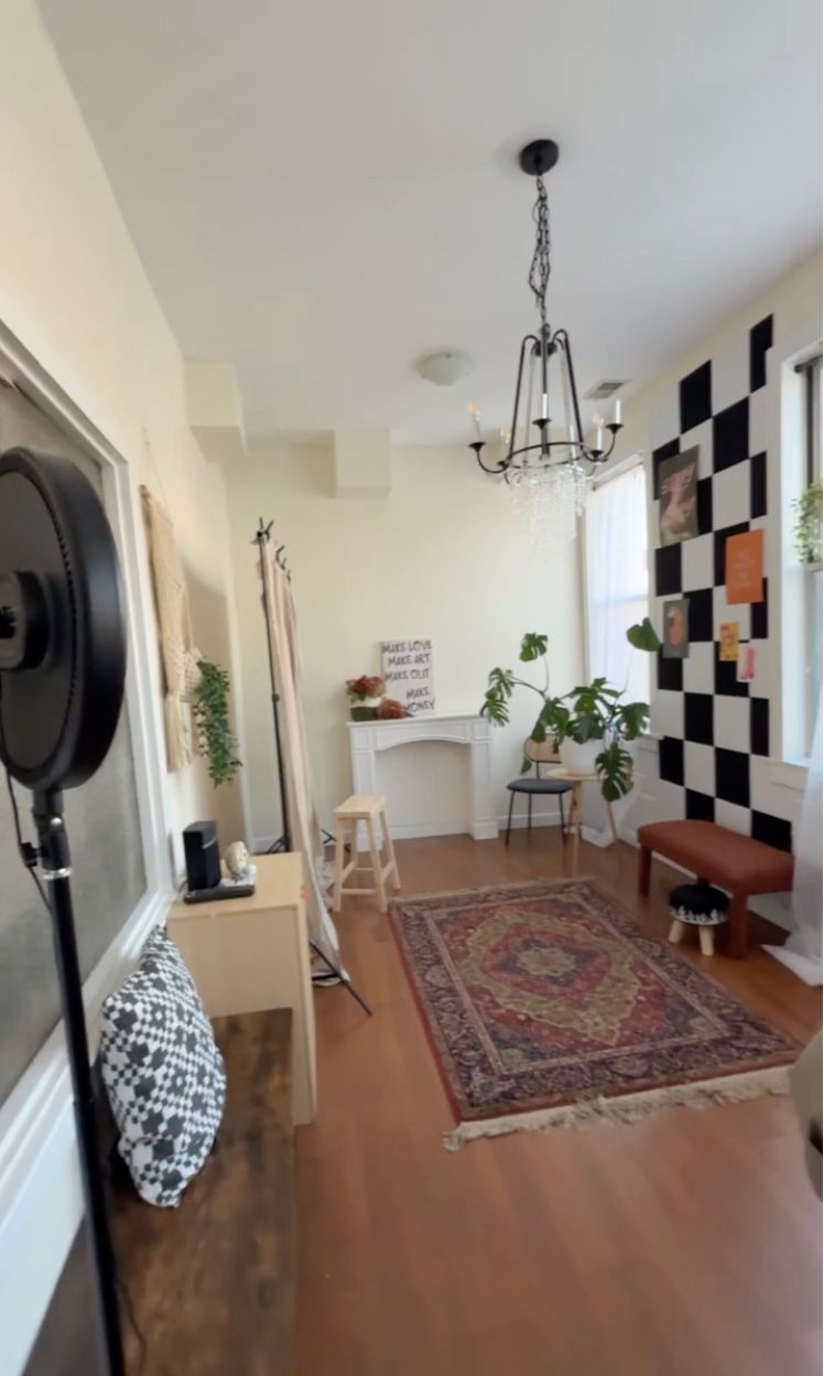 Modern room interior with checkerboard wall art, Persian rug, and hanging light fixtures.