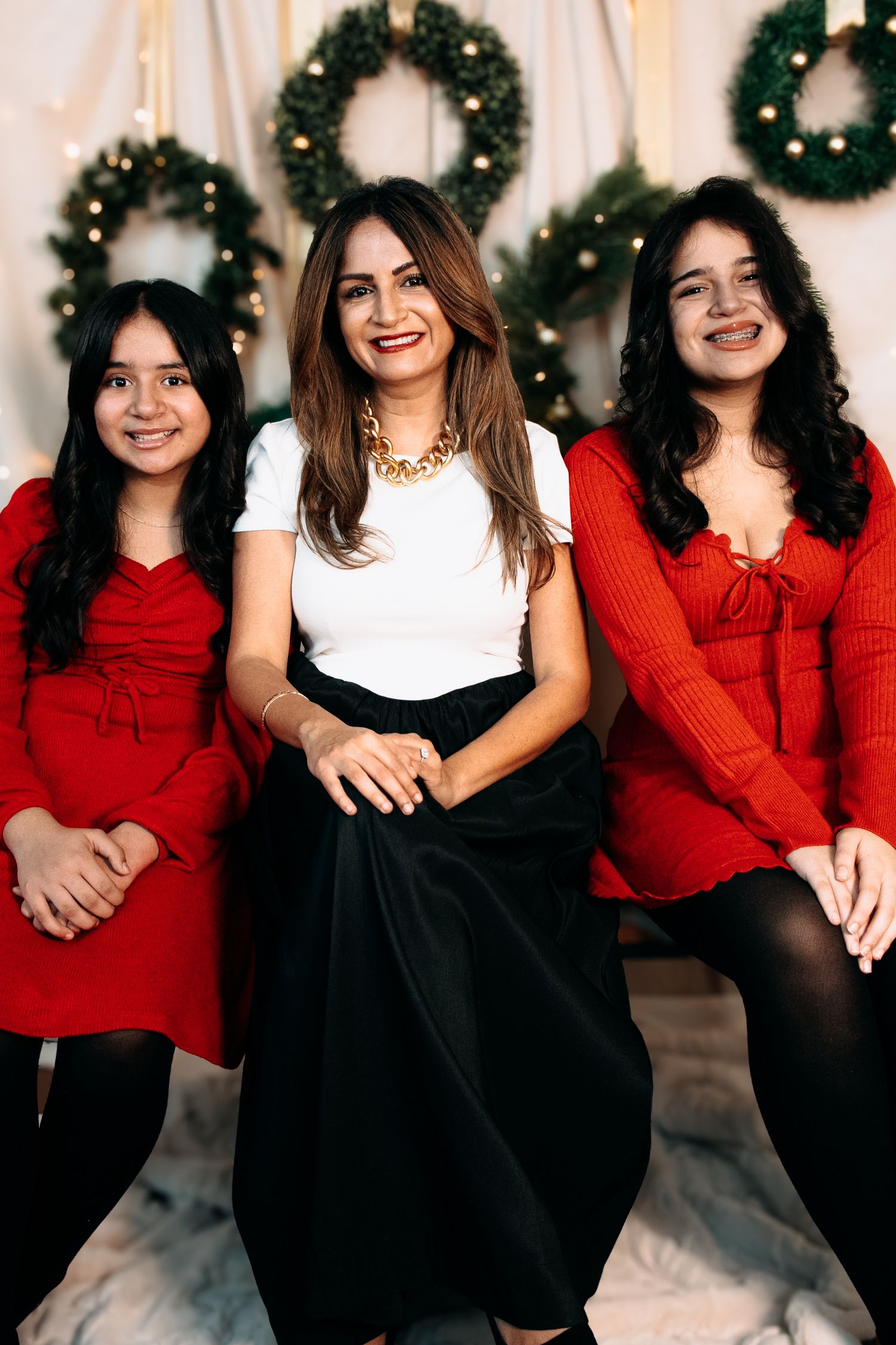 Group photo with people wearing red and black outfits sitting together with Christmas decorations.