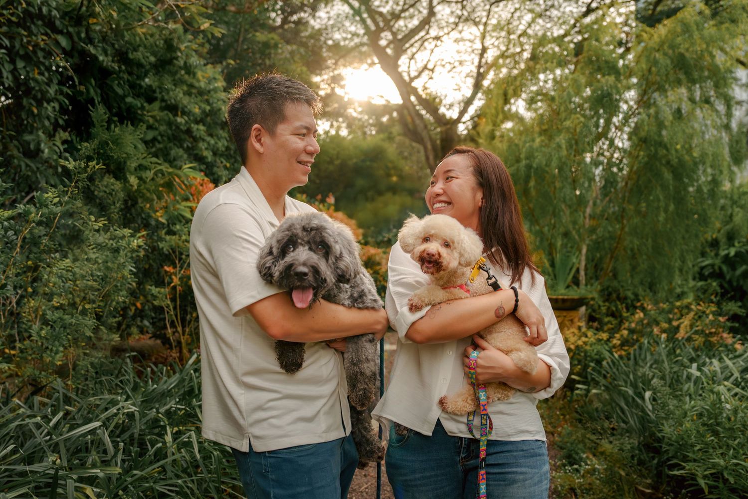 Joyful outdoor family photoshoot with pets in a natural setting.