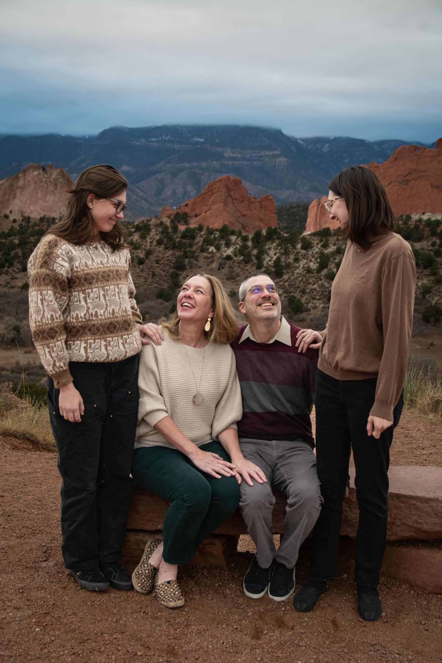Family of four smiling together at Garden of the Gods Colorado scenic overlook.