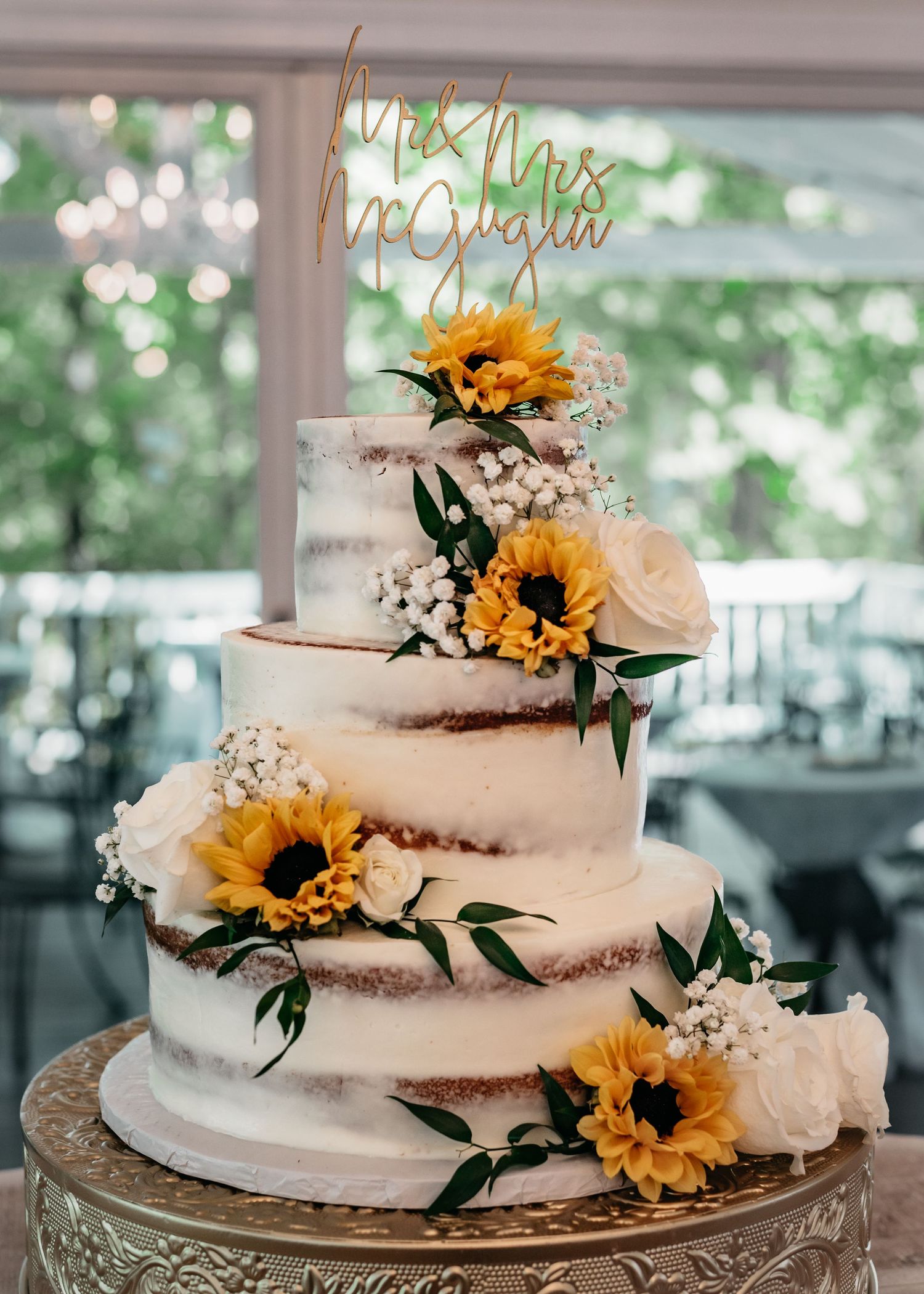 Detailed shot of three-tier wedding cake with sunflowers and baby's breath, captured by Catch Your Fire Photography in Huntsville, AL.