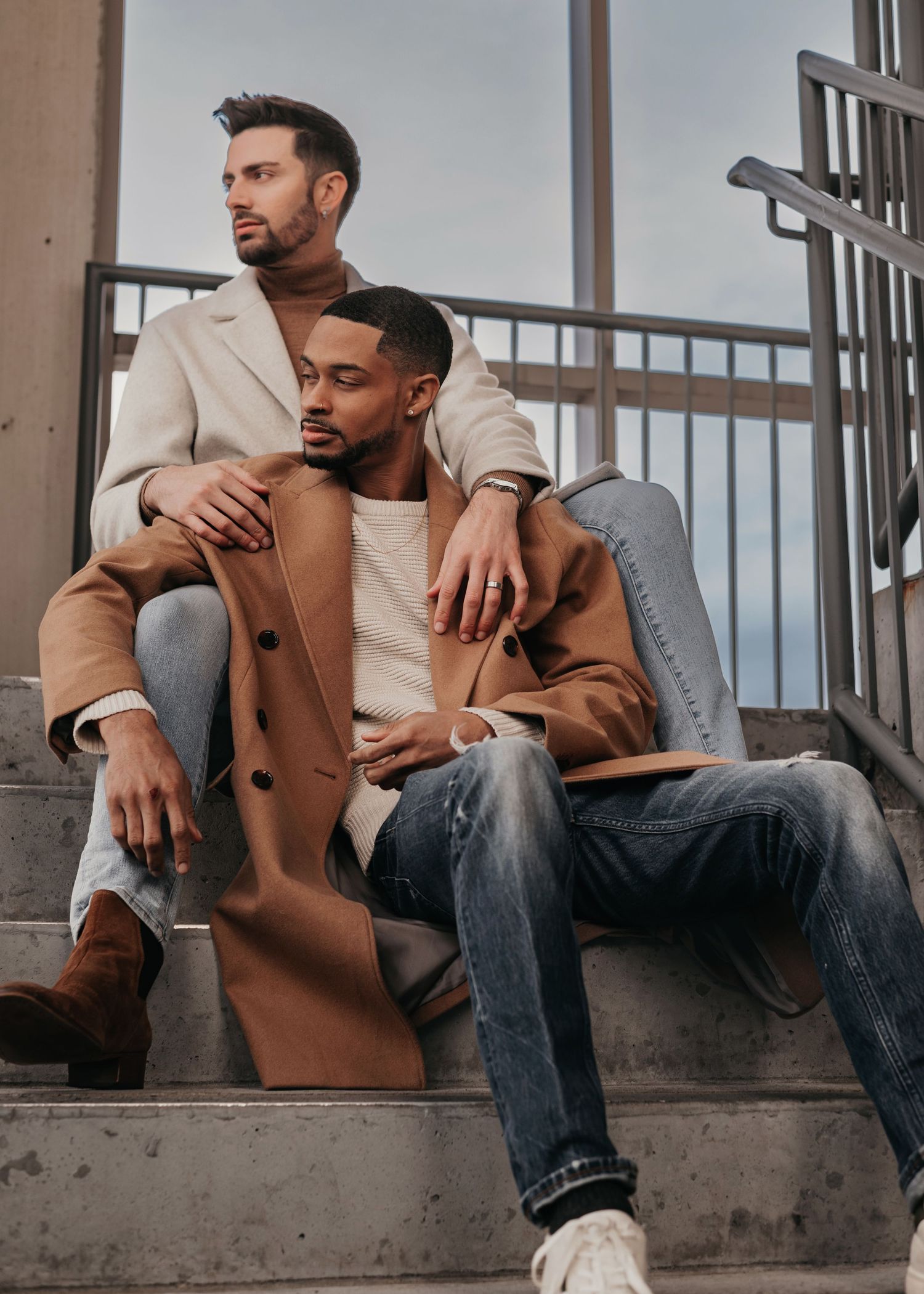 LGBTQ+ couple sitting on stairs during Bridge Street engagement session