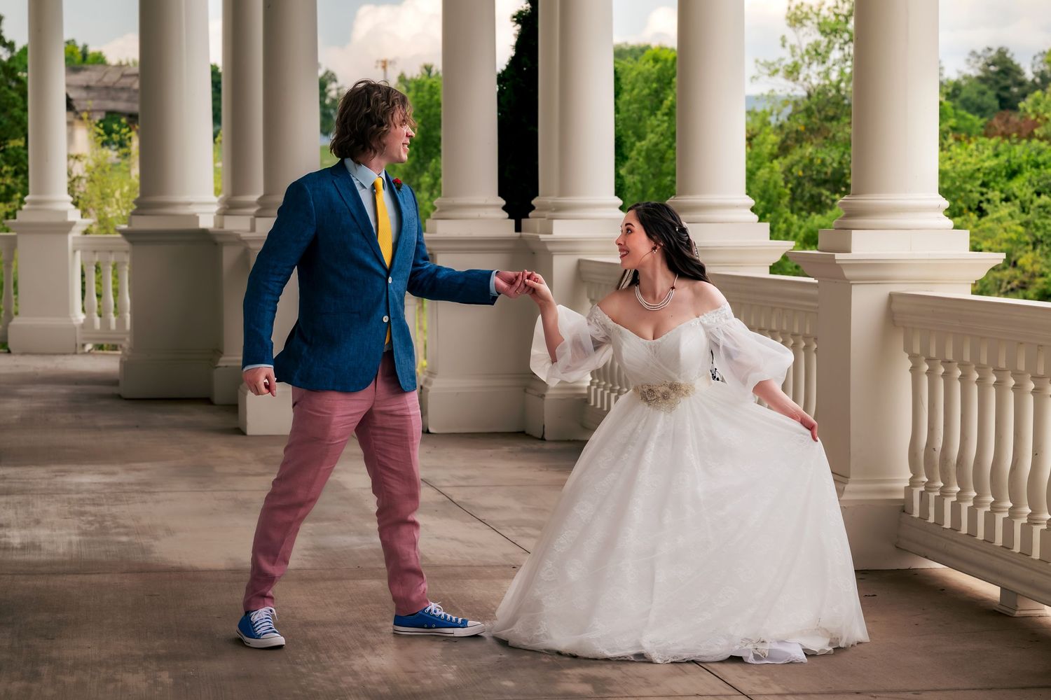 Groom inviting bride to dance while bride curtseys to him at Huntsville Botanical Garden