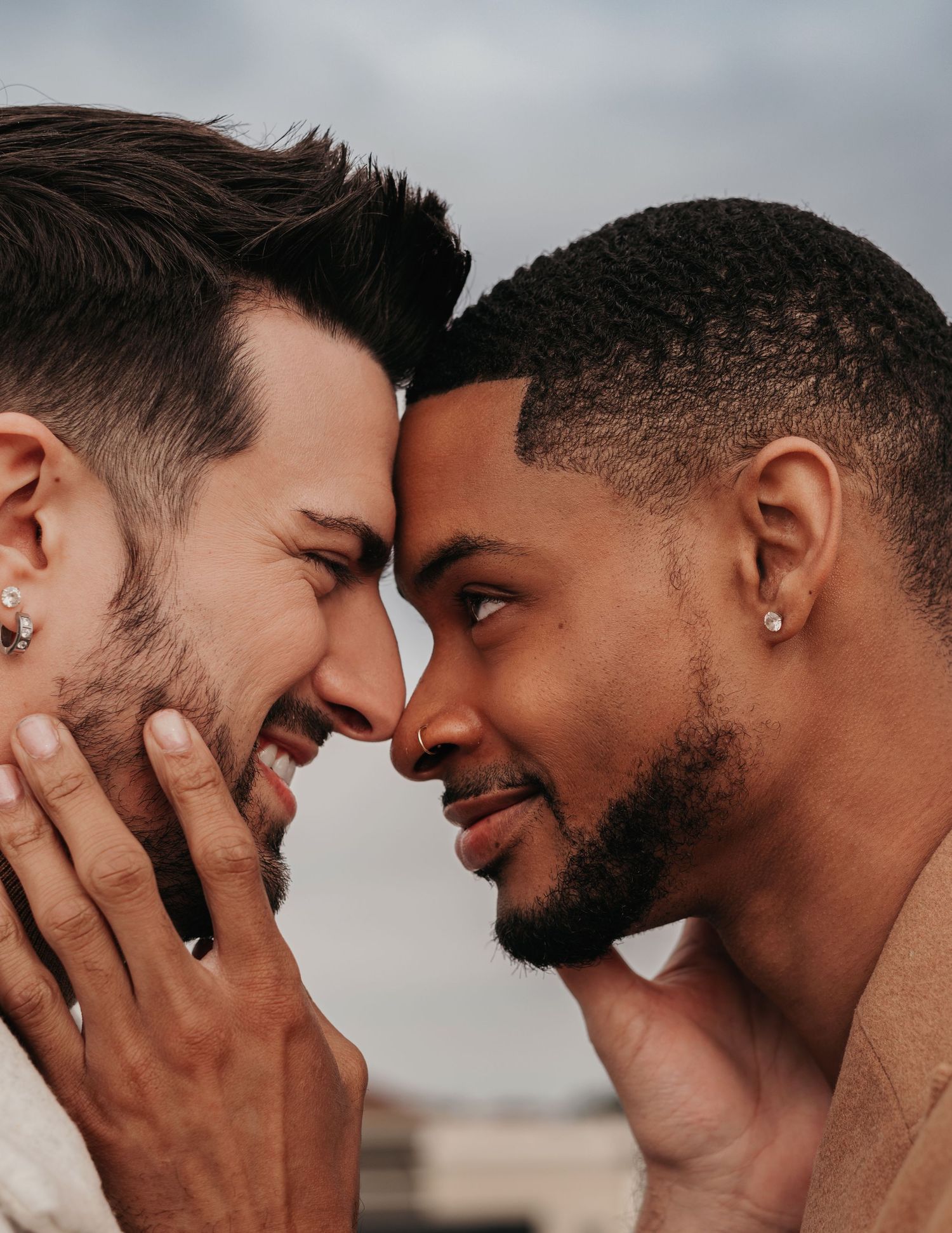 closeup image of interracial same sex couple, foreheads touching