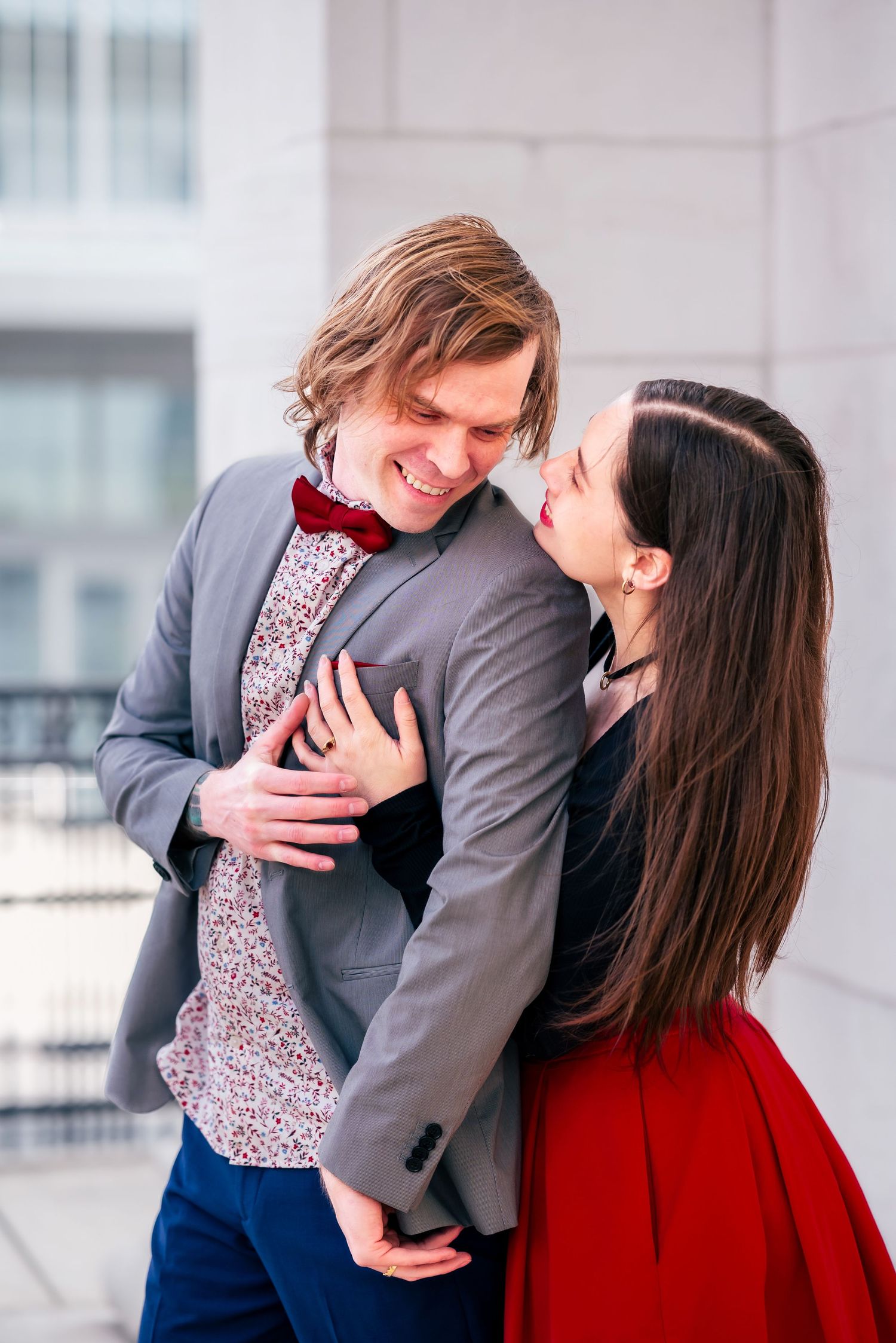 candid moment during downtown engagement session, she hugs him from behind as he look to her and smiles captured by Catch Your Fire Photo