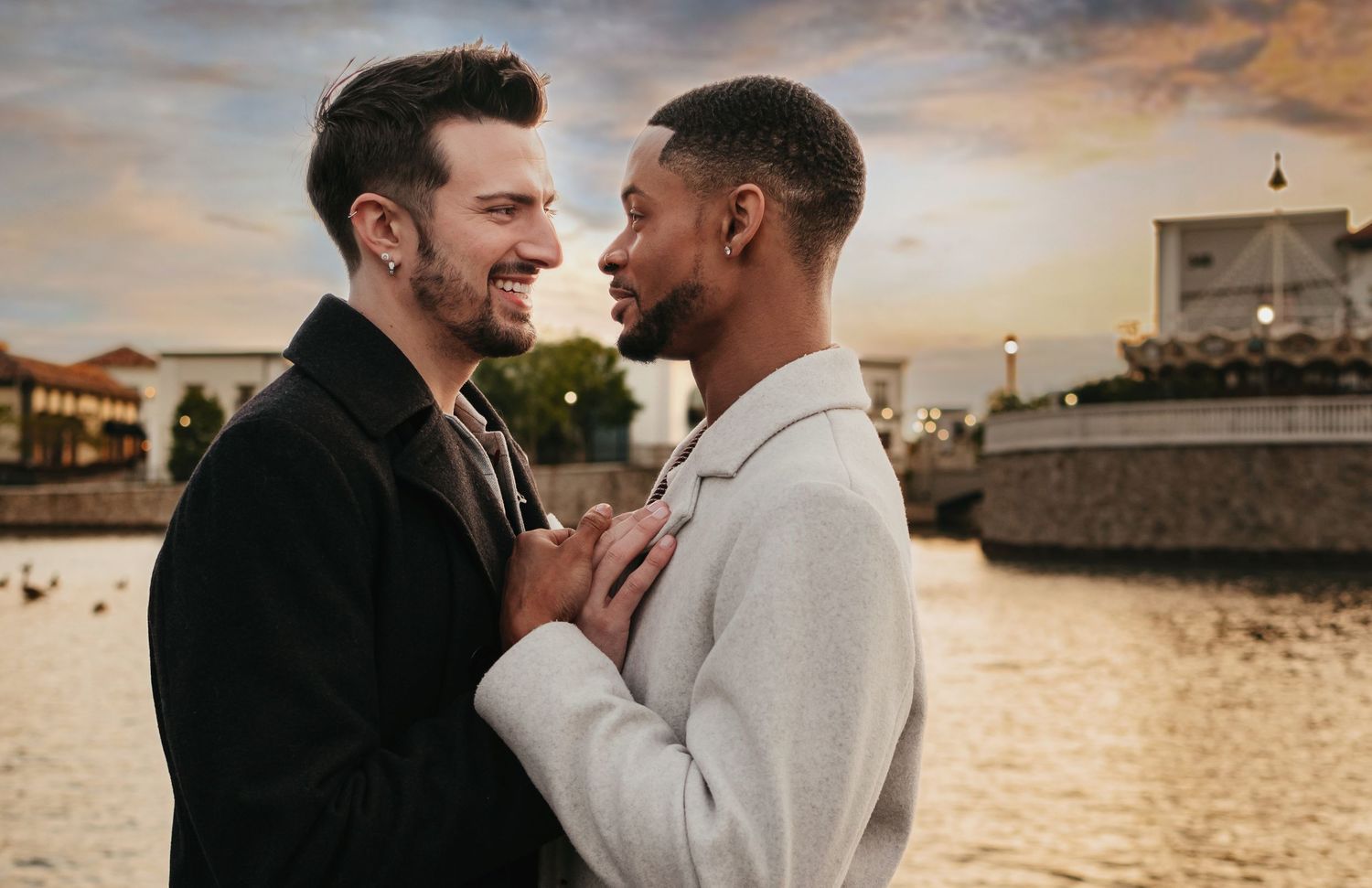 LGBTQ+ couple embracing near waterfront at The Westin at Bridgestreet - Huntsville during golden hour