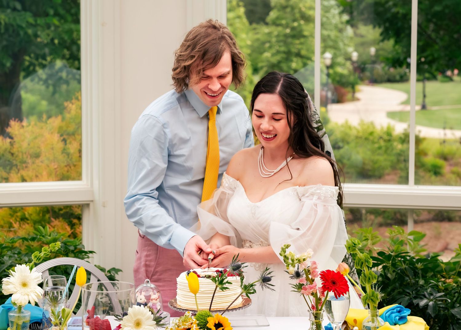 Wedding couple cutting cake at the Observatory, Huntsville Botanical Garden, photographed by Catch Your Fire Photography.