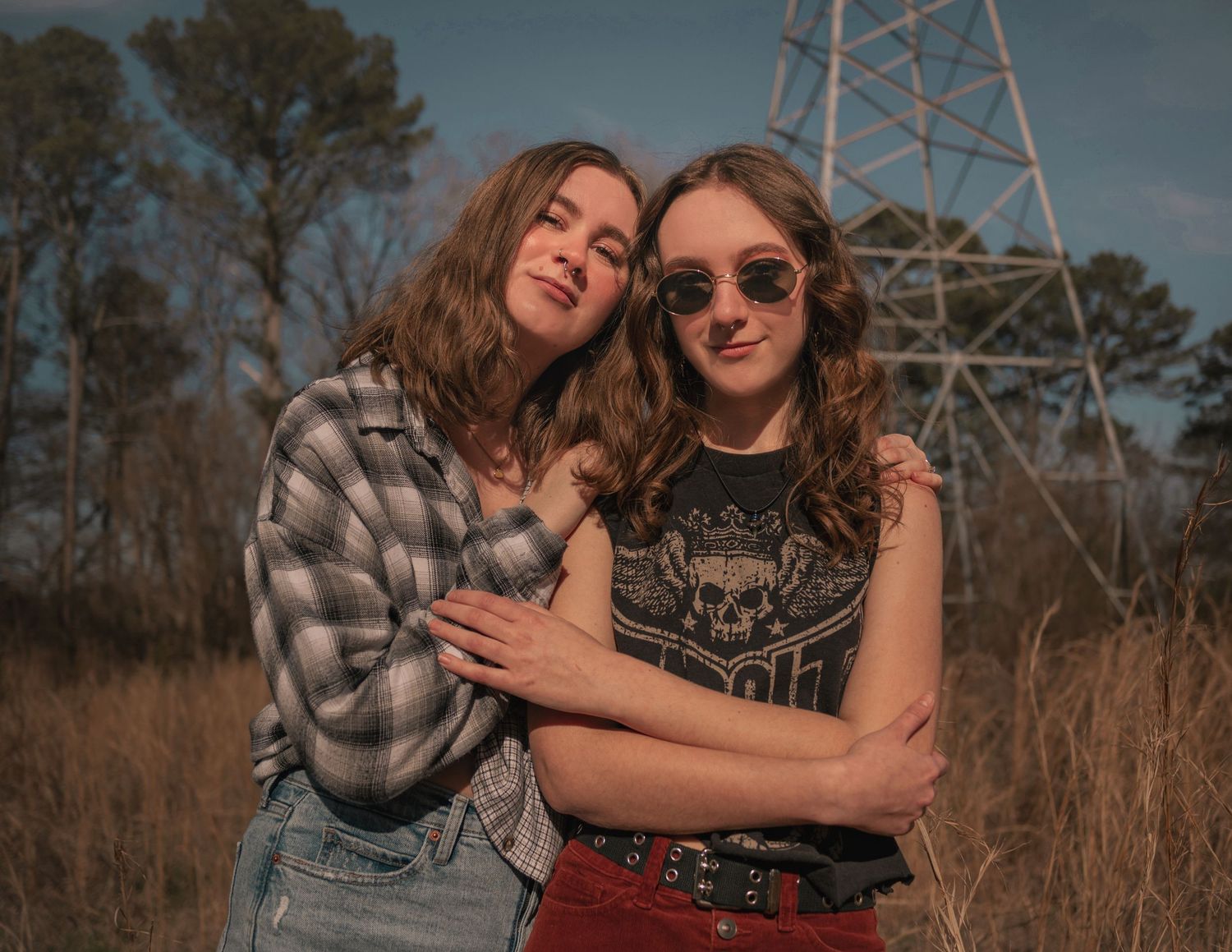 close up casual photo of two sisters hanging out in a overgrown field in Huntsville, AL.