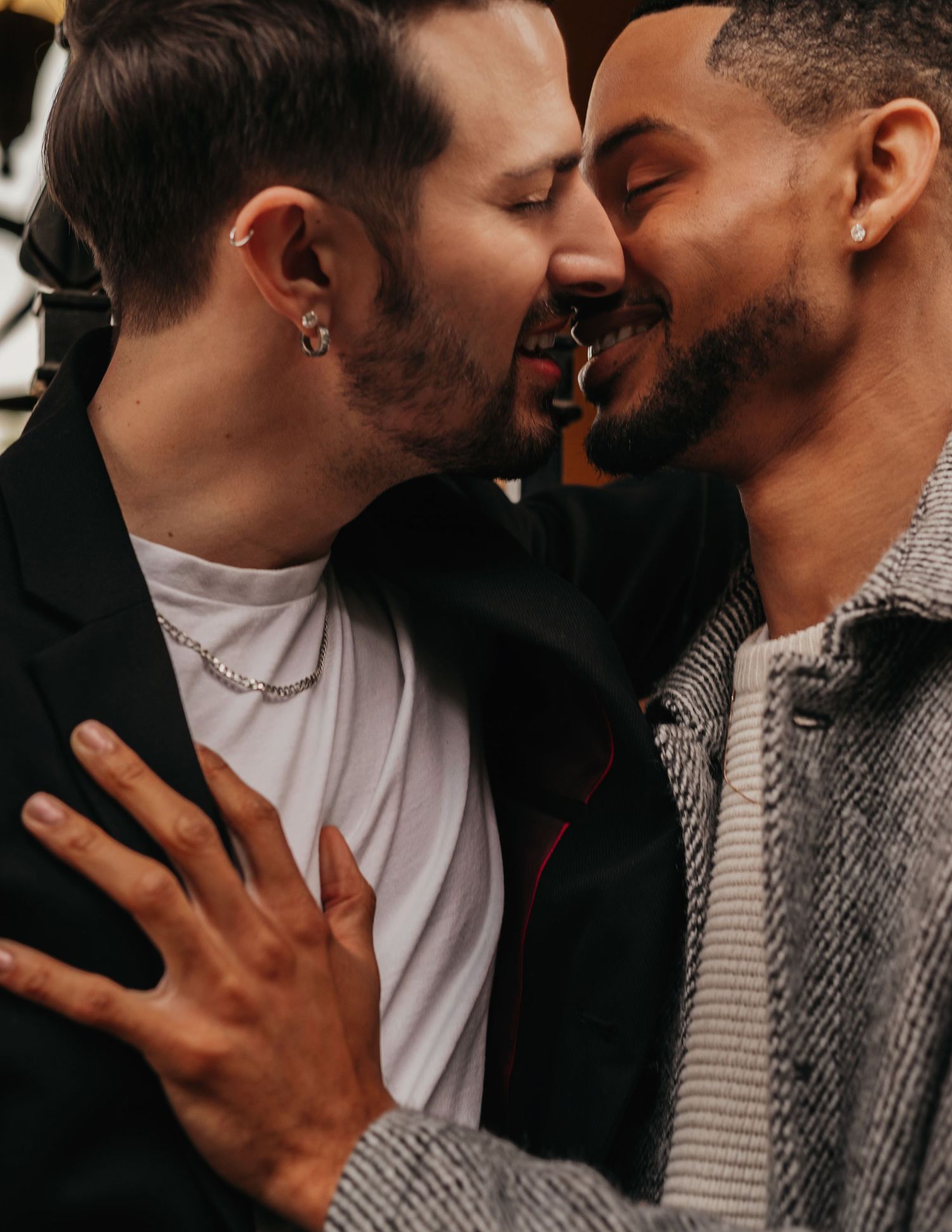 Two grooms sharing a tender kiss surrounded by courtyard architecture