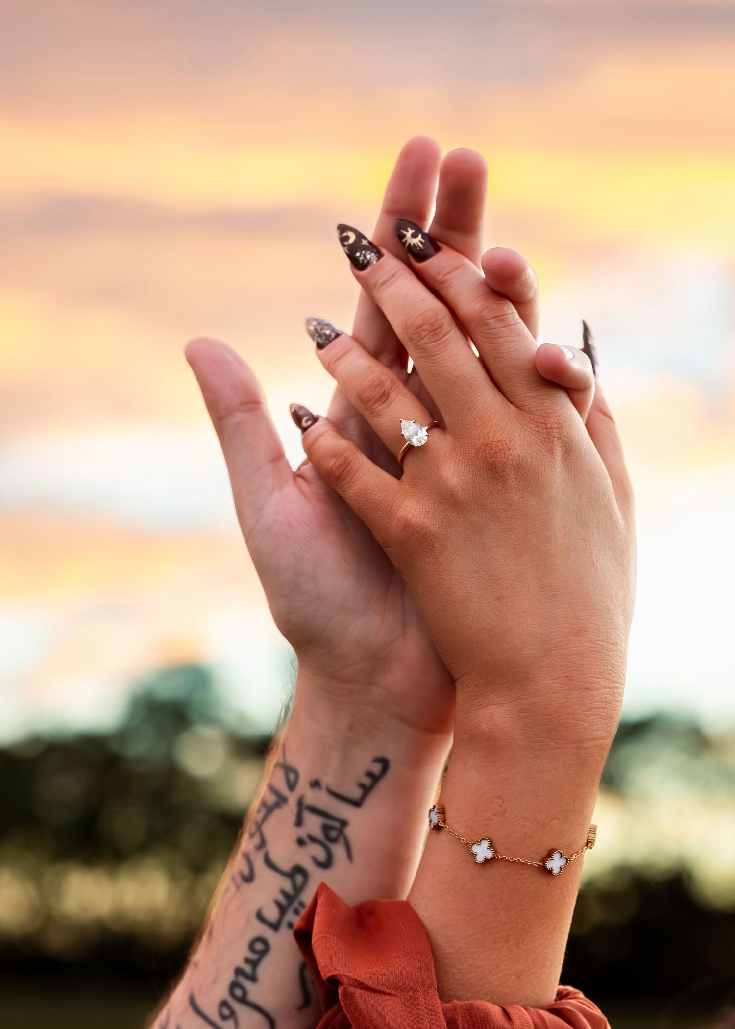 Tate Farms engagement detail of couple’s hands raised at sunset, showing ring, captured by Catch Your Fire Photography.