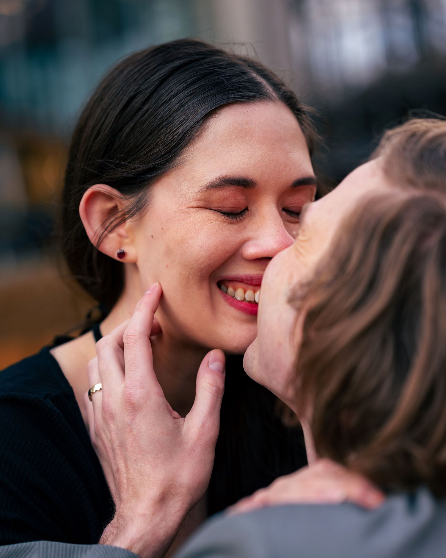 Close-up engagement portrait of couple, her smiling as he leans in for a kiss, captured by Catch Your Fire Photography in Huntsville, AL.